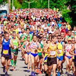 Energetic marathon runners competing on a sunny day, showcasing perseverance and community spirit.